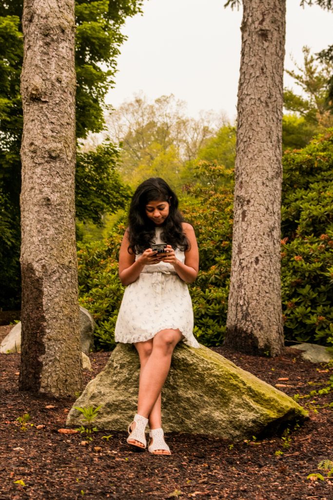 Girl surrounded by beautiful nature, but lost in their phone.