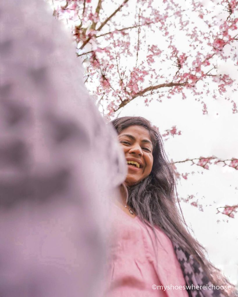 Selfie with a tripod to show spring blossoms above me