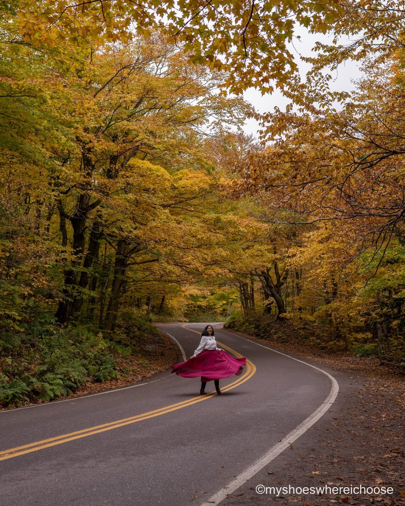 new england fall road trip - foliage on curved roads at smugglers notch stowe vermont